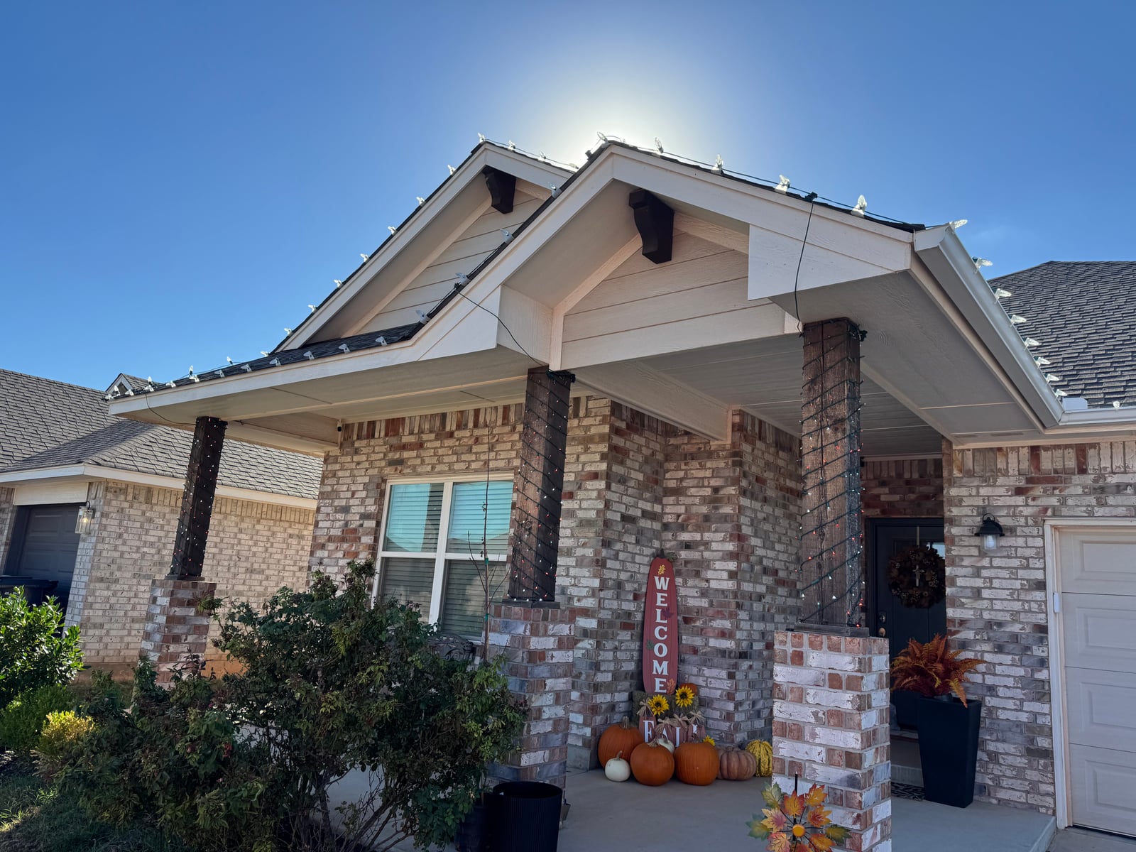 Christmas light installation on roofline and wrapped porch posts