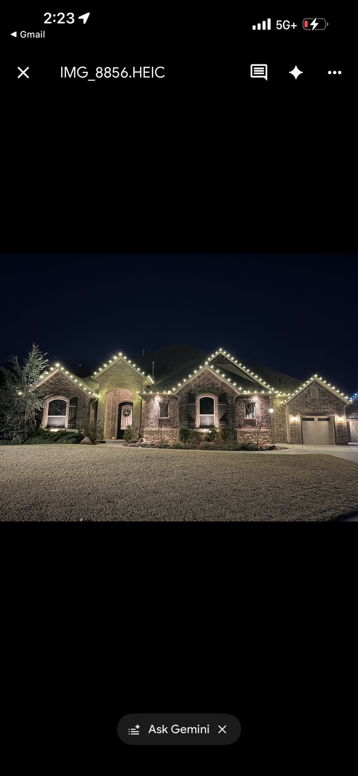 Warm white roofline Christmas lighting installation on residence